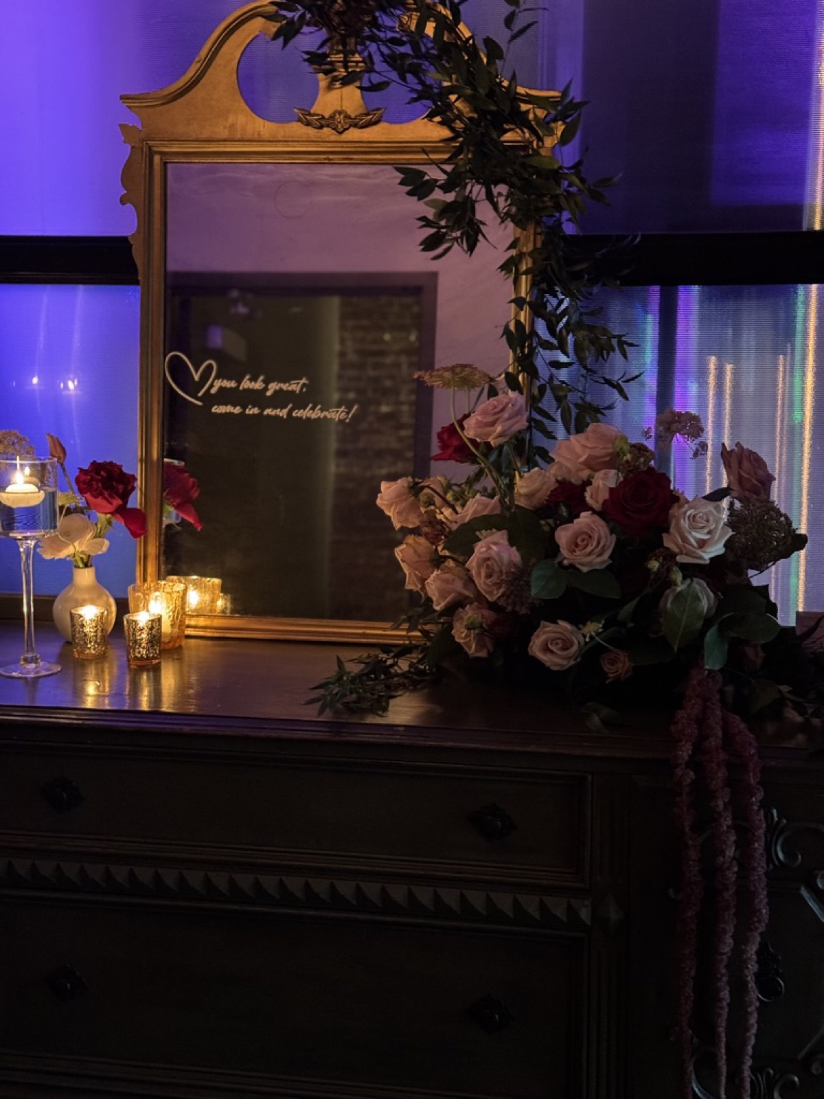 Wedding reception centerpiece with mirror, candles, and dusty rose flowers