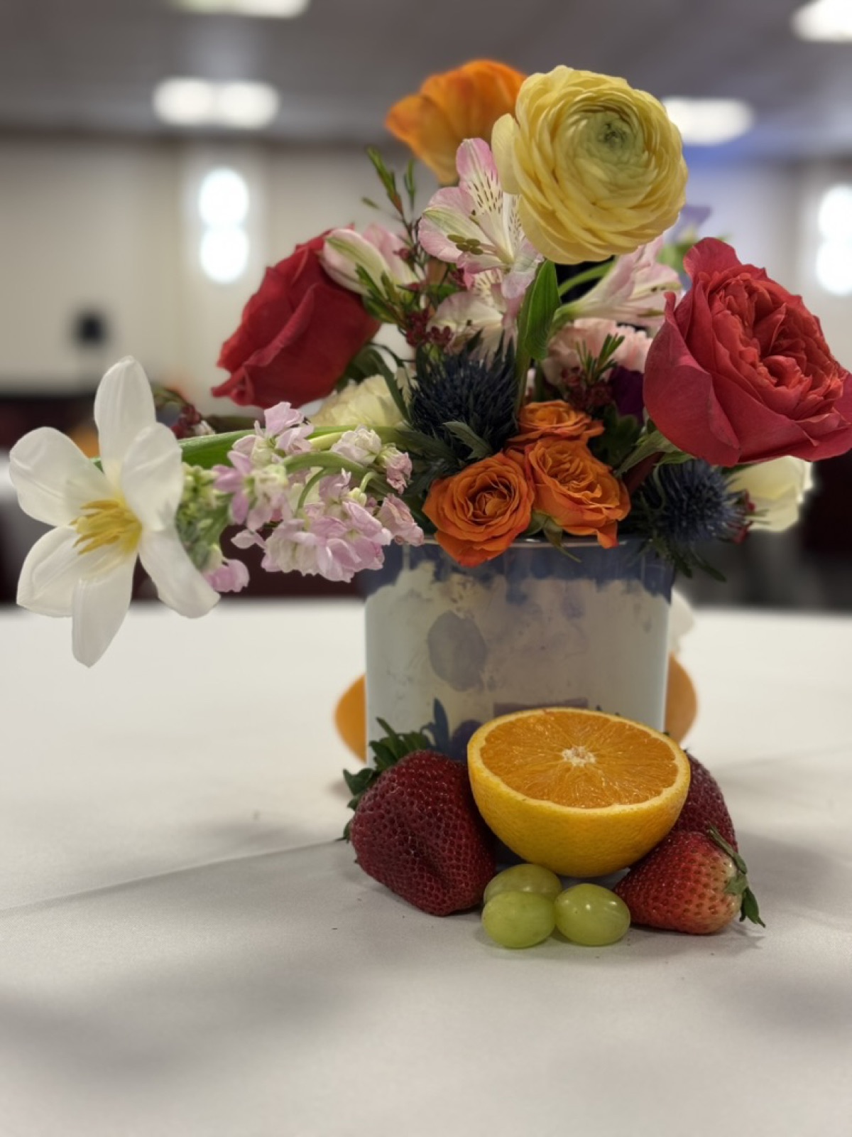 Gala centerpiece styled with mixed flowers and fresh fruit
